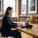 Femme en blazer travaillant sur un ordinateur dans un studio moderne